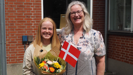 FOA Odenses formand Nina Skov-Lauridsen lykønsker velfærdstalent Josephine Theilgaard med flag og buket